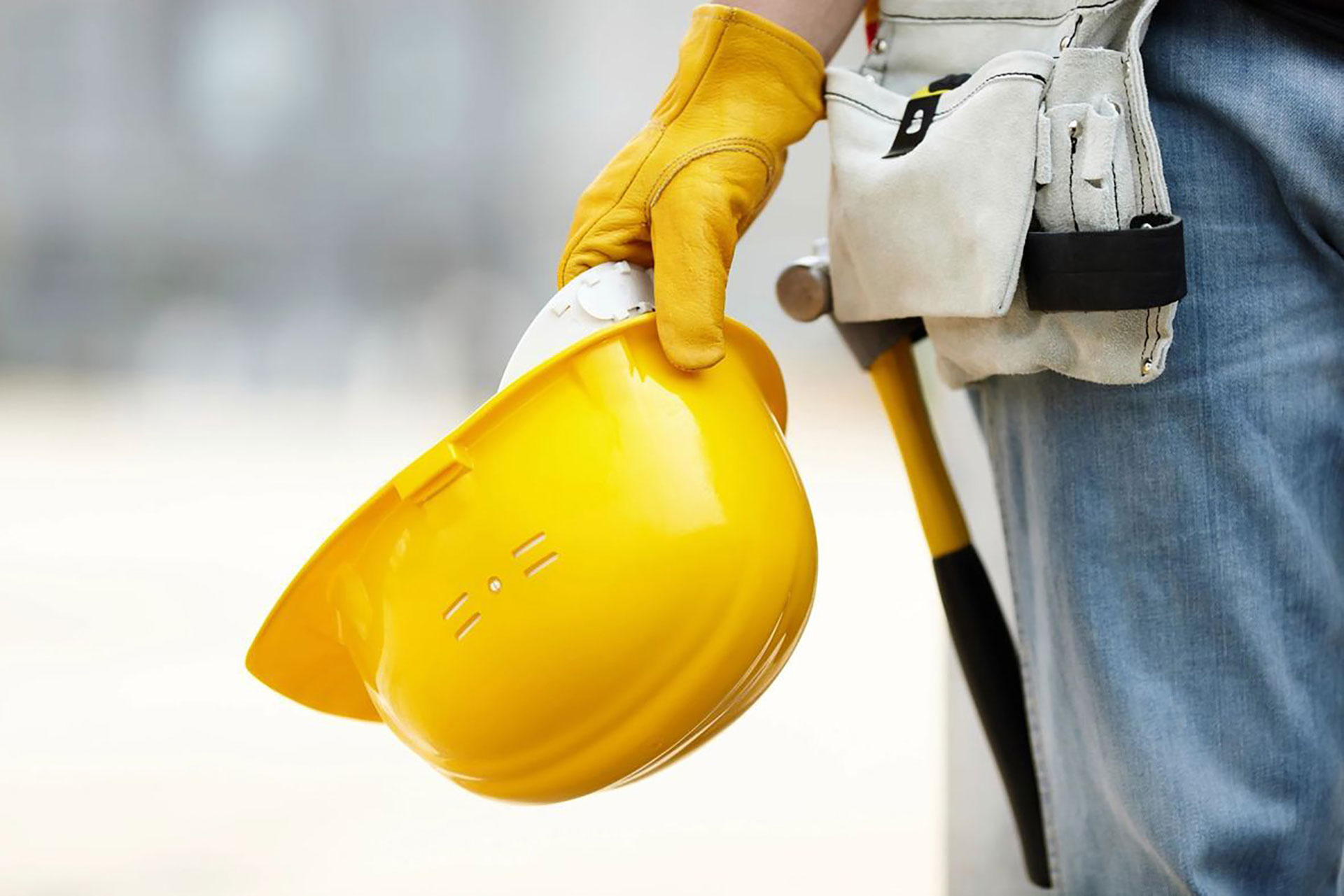 construction worker holding yellow safety hard hat